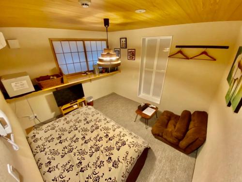 東京にあるHotel EL Shinjuku 6のベッドと椅子付きの小さな部屋です。