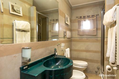 a bathroom with a green sink and a toilet at Hotel Kent in Rome