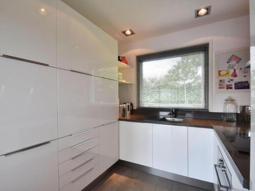 cocina blanca con fregadero y ventana en Riverside holiday home near Amsterdam en Nigtevecht