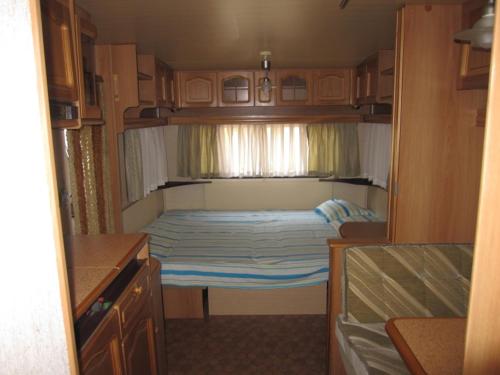 a small bed in the back of an rv at Camping Tsitreli in Kalamitsi