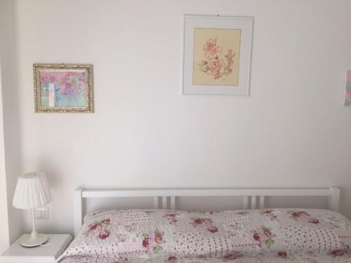 een slaapkamer met een bed en een schilderij aan de muur bij La Vie En Rose in Rapallo