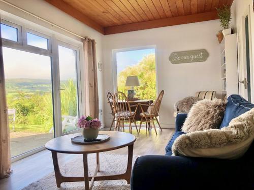 a living room with a blue couch and a table at Ballygally Seaview and Garden Hideaway in Ballygalley