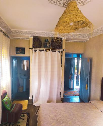 a bedroom with a bed and a ceiling at Le petit Jardin in Demnat