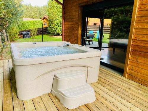 a bath tub sitting on a wooden deck at Le Hygge Chalet Gérardmer-Spa in Anould