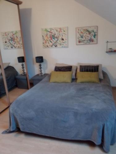 une chambre avec un grand lit avec une couverture bleue dans l'établissement La longère, à Épineu-le-Chevreuil