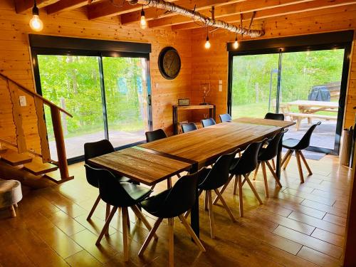 a large wooden table and chairs in a room at Le Hygge Chalet Gérardmer-Spa in Anould