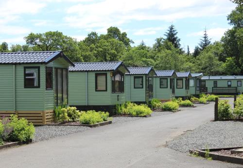 a row of green cabins in a row at Inverbeg Holiday Park in Luss