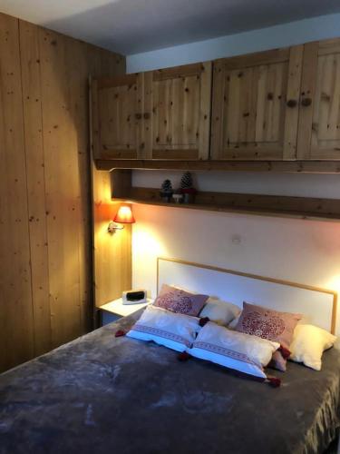 - une chambre avec un grand lit et des placards en bois dans l'établissement IDEAL, à La Plagne Tarentaise