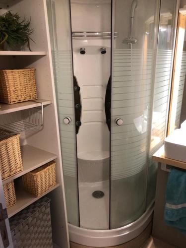 une douche avec une porte vitrée dans une salle de bain dans l'établissement IDEAL, à La Plagne Tarentaise