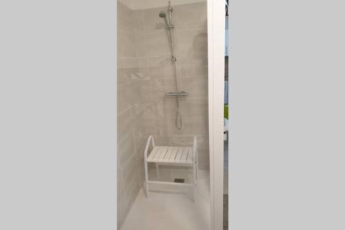 La salle de bains est pourvue d'une douche avec un banc. dans l'établissement Bel appartement dans residence de standing neuve, à Châtel-Guyon