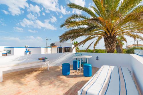 a bedroom on the roof of a house with a palm tree at Casas Típicas Algarvias in Arroteia de Baixo