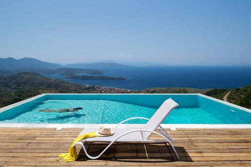 a chair sitting next to a swimming pool at Esperos Suites & Villas in Lafkos