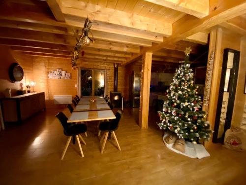 a christmas tree in a room with a table and chairs at Le Hygge Chalet Gérardmer-Spa in Anould