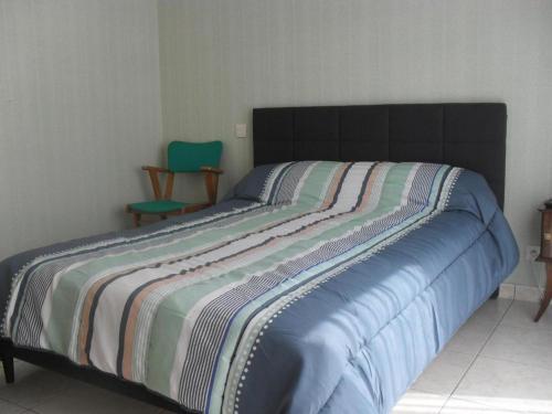 - un lit avec une couverture rayée dans une chambre dans l'établissement Chateaubriand, à Saint-Cast-le-Guildo