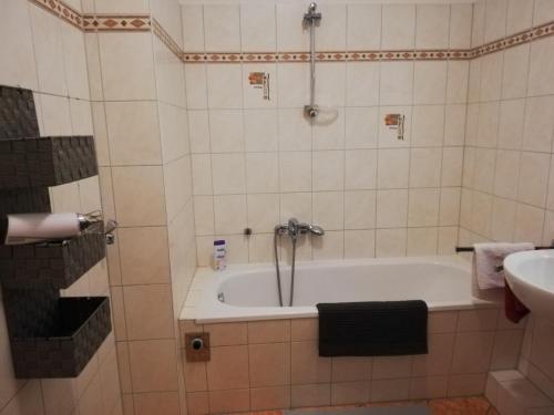 ein Badezimmer mit einer Badewanne und einem Waschbecken in der Unterkunft Apartment Dresden City Centre in Dresden