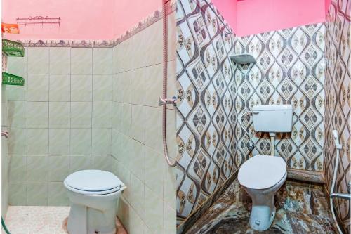 a bathroom with a toilet and a sink in it at Ijen Traveller & Homestay in Banyuwangi
