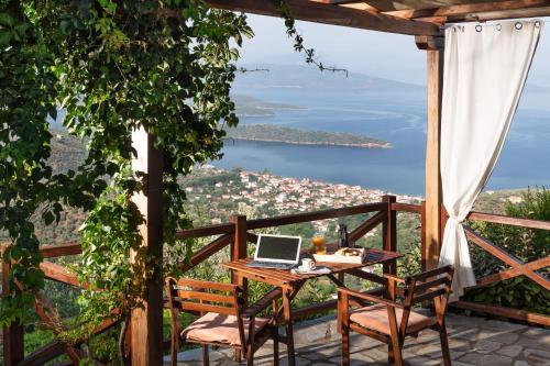 a table with a laptop on top of a balcony at Esperos Suites & Villas in Lafkos