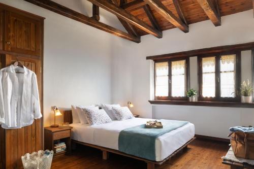 a bedroom with a bed and two windows at Esperos Suites & Villas in Lafkos