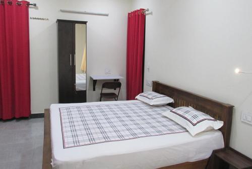 a bedroom with a bed with red curtains at Nature Villa Kochi in Alwaye