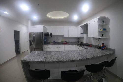 a kitchen with a large island in the middle at Paraíso en Rosarito a pie de la playa in Rosarito