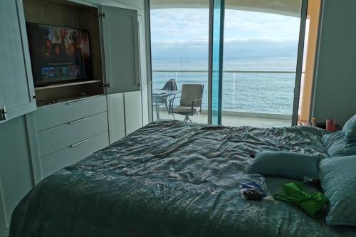 a bedroom with a bed with a view of the ocean at Paraíso en Rosarito a pie de la playa in Rosarito