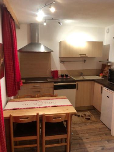une petite cuisine avec une table et une cuisinière four supérieur dans l'établissement IDEAL, à La Plagne Tarentaise