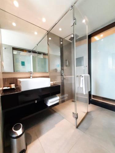 a bathroom with a large sink and a shower at ZIBE Salem By GRT Hotels in Salem