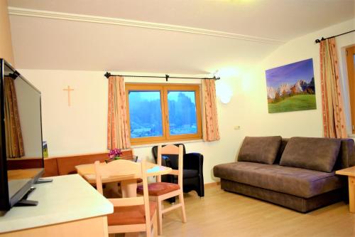 a living room with a couch and a table at Ferienwohnung Saalbach Fieberbrunn in Fieberbrunn