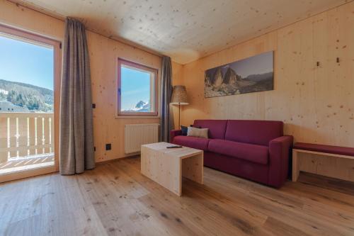 a living room with a purple couch and a large window at Panorama in Sesto