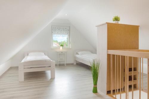 a white room with two beds and a window at Residenz 2 in Heiligenhafen