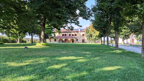 a large yard with trees in front of a house at Agriturismo La Foscarina in Vescovana