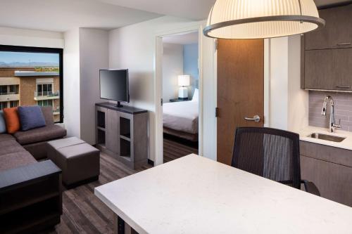 a hotel room with a kitchen and a living room at Hyatt House North Scottsdale in Scottsdale