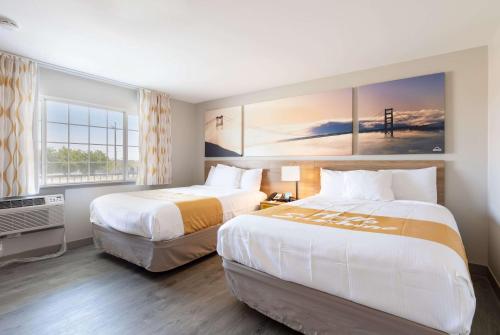 a hotel room with two beds and a window at Days Inn by Wyndham Red Bluff in Red Bluff