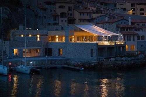 a large building with a dock in the water at night at PORTOPICCOLO Luxury Penthouse Beach Included in Sistiana