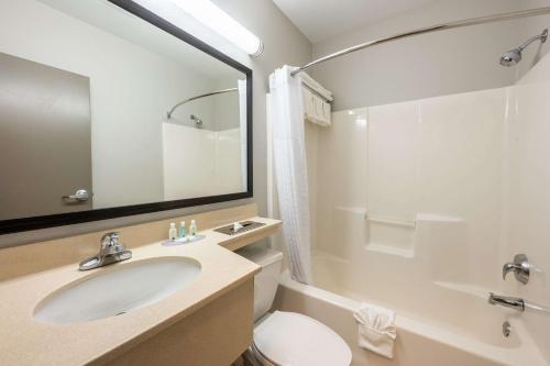 a bathroom with a sink and a toilet and a mirror at Quality Inn Poughkeepsie in Poughkeepsie