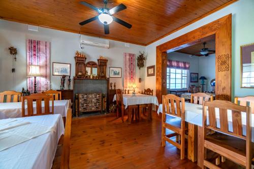 a dining room with two beds and a ceiling fan at Old Coach Road Guest House in Barberton