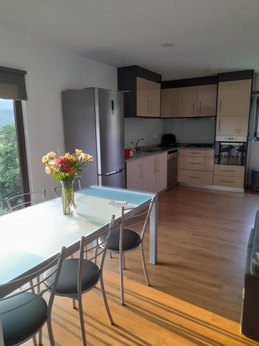 a kitchen with a table and two chairs and a table and a kitchen at Casa dos Cortinhais in Vieira do Minho