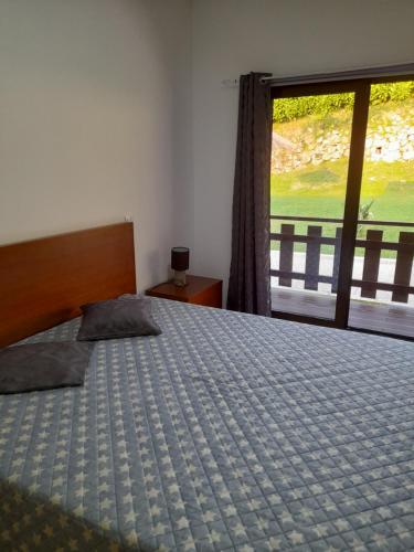 una camera da letto con un letto e una grande finestra di Casa dos Cortinhais a Vieira do Minho