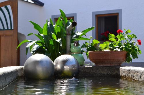 a fountain with some plants and a water feature at Ferienhof Naderhirn - Bauernhof in Wegscheid