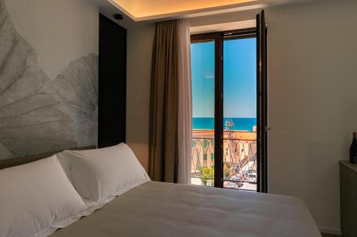 a bedroom with a bed with a view of the ocean at PALAZZO RAHO SUITES in Cefalù
