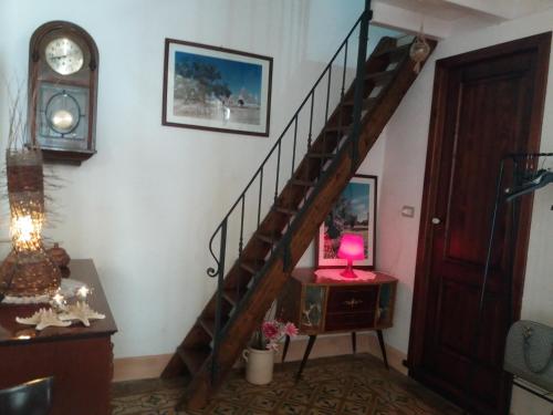 a staircase in a room with a table and a clock at Casa Cassiano in Patù