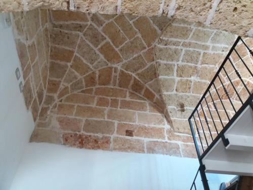 a stone staircase in a room with a brick wall at Casa Cassiano in Patù