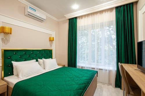 a bedroom with a green bed and a window at Arion Hotel in Moscow