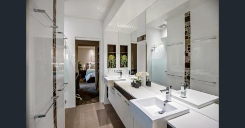 a white bathroom with two sinks and a mirror at Red Lotus Guesthouse in Mudgee