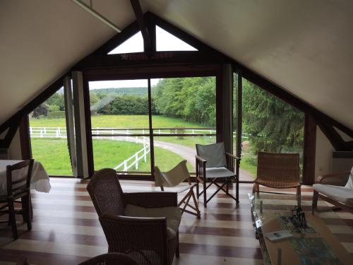a room with a large window with chairs and a view at Chambre d'hôtes de Charleval in Charleval