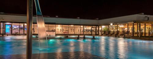 un edificio con piscina por la noche en Dorint Parkhotel Bad Zurzach, en Bad Zurzach