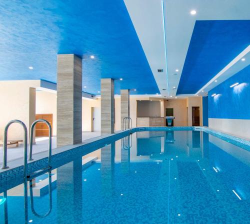 a swimming pool in a hotel with a blue ceiling at Hotel Agape in Zlatibor