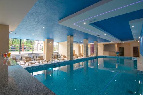 a swimming pool in a hotel with a blue ceiling at Hotel Agape in Zlatibor
