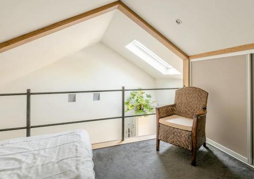 een slaapkamer met een bed, een stoel en een raam bij Slaperij ‘t Woud - Near the dunes and the sea! in Bergen