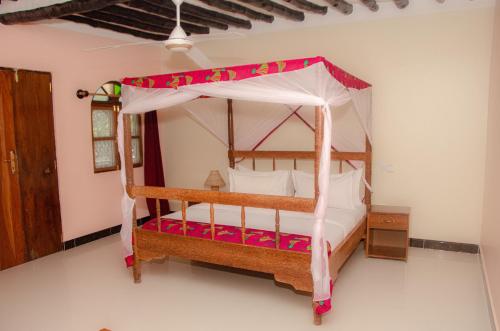 a bedroom with a bed with a canopy at Sunbrella Boutique Hotel in Michamvi